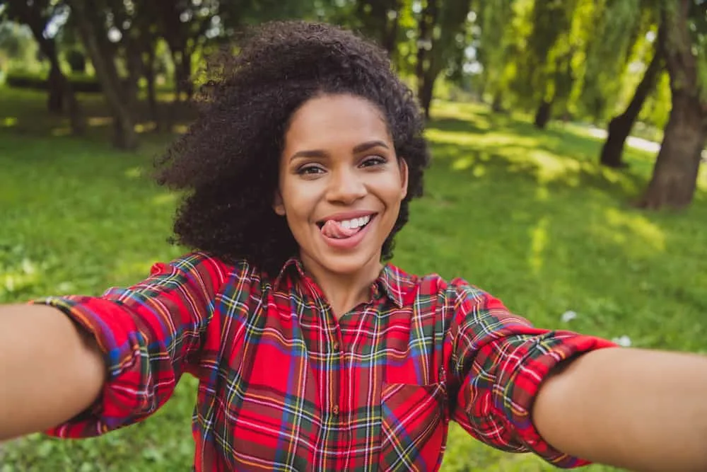 Teenage girl with medium-length curly locks wearing a layered haircut on her 4A thick hair strands.