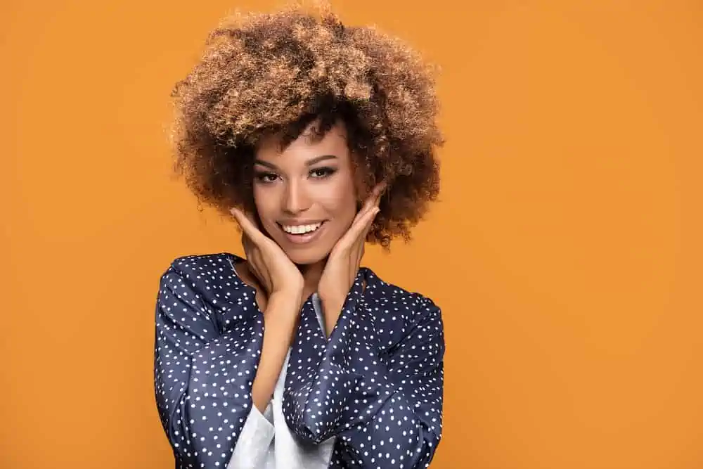 Pretty young black girl wearing a blue dress with curly hair dyed with semi-permanent colors.