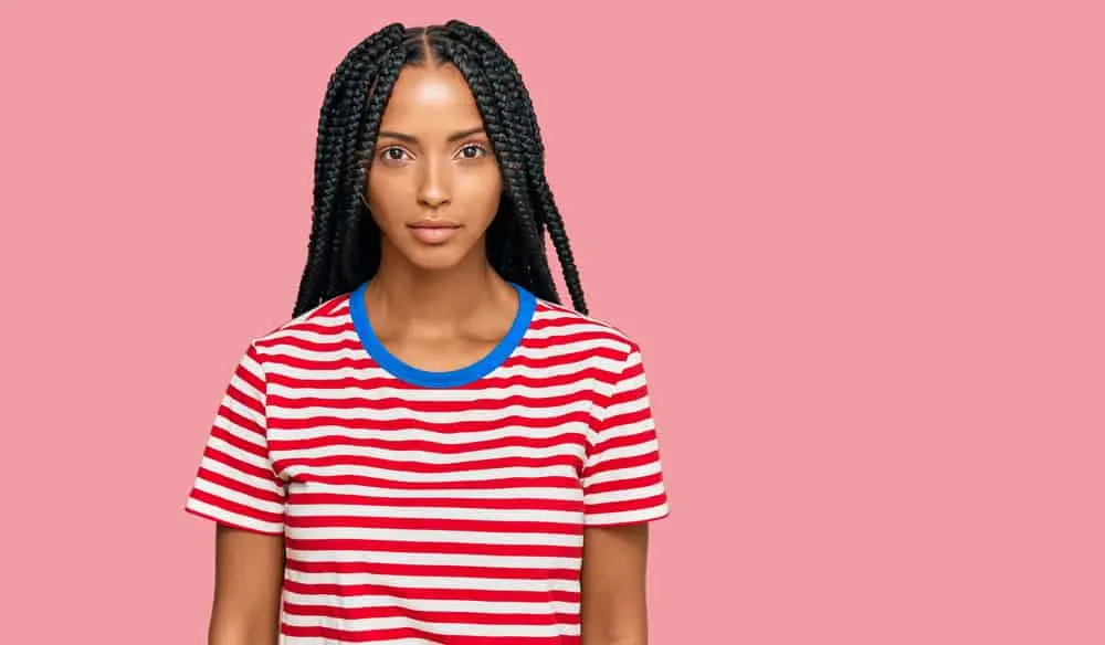 A light-skinned woman wearing tight braids that are very popular in West Africa and among some native American women.