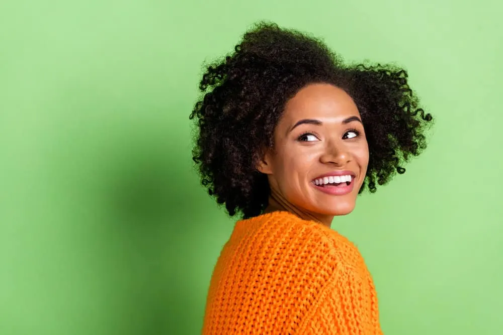 An African American girl that recently covered her blonde hair tips with dark brown hair color.