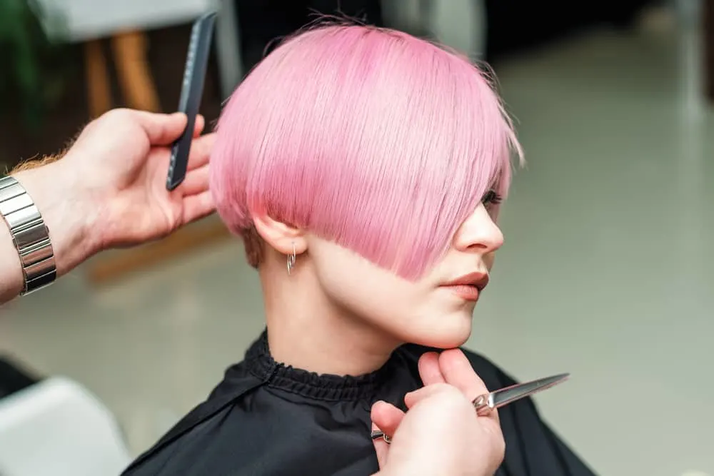 Professional stylist at Mastercuts Services cutting hair after a semi-permanent hair color to get all-over smoothness.