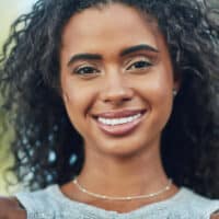 Attractive young African American woman with a fine hair type styled using the curly girl method.