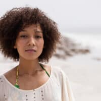 African American female with naturally wavy hair feels dry after swimming in the ocean and enjoying the natural waves.