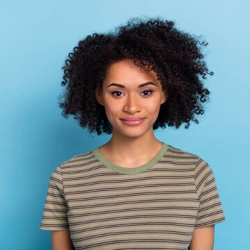 Cute African American female with healthy hair growth wearing hair extensions on her fine hair to create fullness.