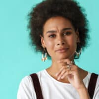 Young black woman with colored hair cuticles after using a mixture of blue and brown permanent dyes.