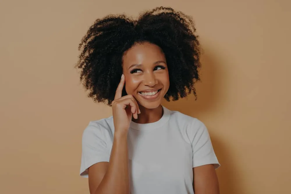 A young black girl with frizzy hair and split-ends has 4A natural curls.