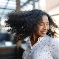 A black female with healthy hair after washing hair with a DIY mix - castile soap and baking soda to eliminate oily hair.