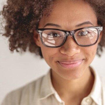 Young African American female with healthy hair growth after suffering from thin hair due to excessive heat styling.