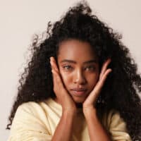 Cute African American female with a 3B hair type showing off her curls after drying her wet hair.