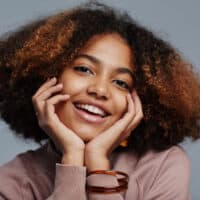 African American female with black and brown curly hair after using Prose shampoo and conditioner.