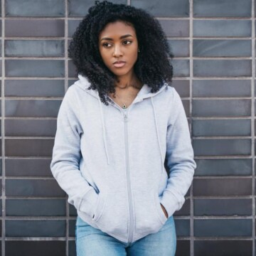 Cute African American female with perfect finger coils on 4A thick hair strands after using a hooded dryer.