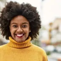 Cute young black girl with dark hair wanting to dye her curls a dark brown shade because she's getting gray hair.