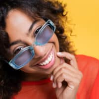 African American female with a medium-hair length has frizz-prone hair after using a hair dryer on her wet hair.