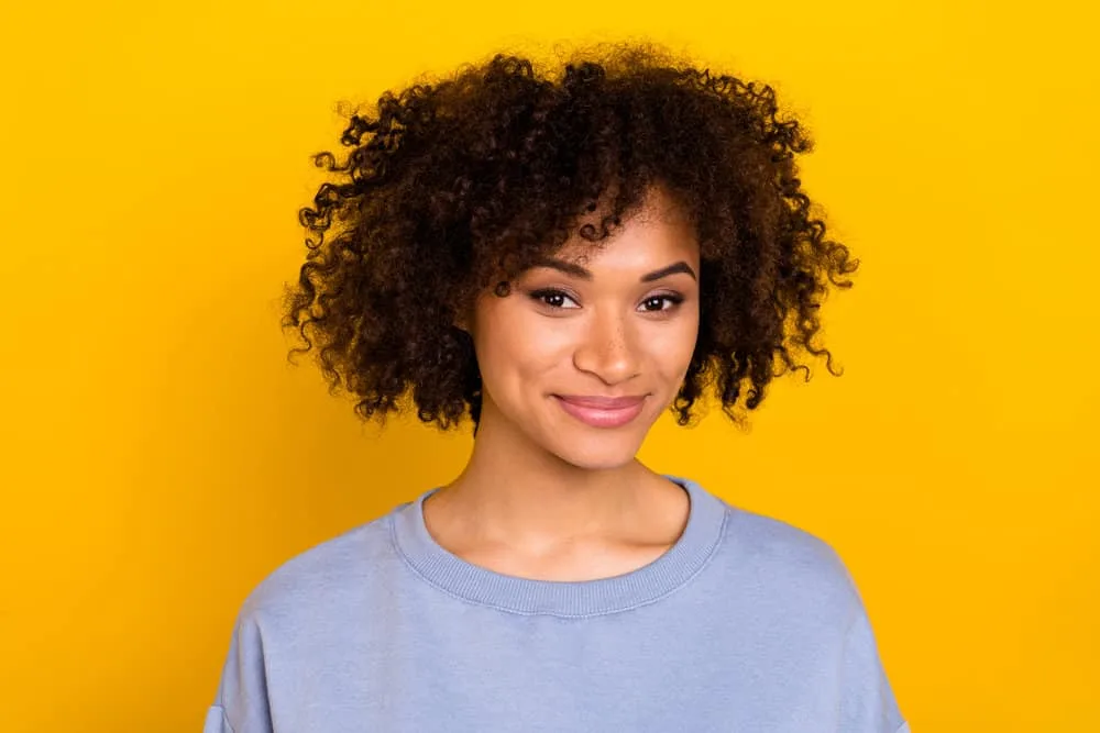 African American female with coily hair strands conditioned with all the ingredients in Cardi's homemade hair mask.