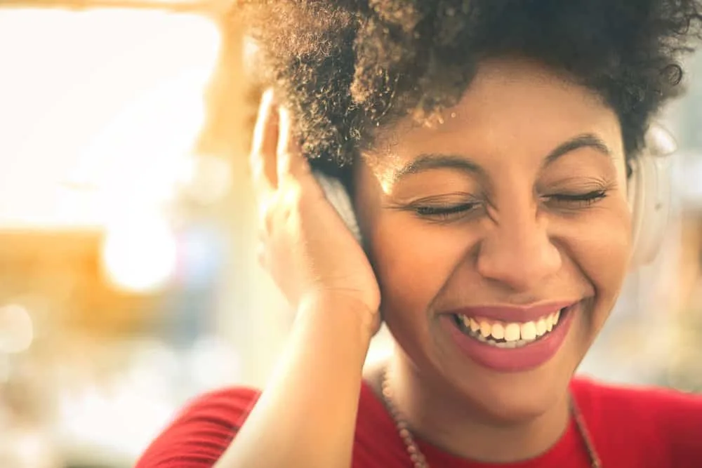 Young African American girl listening to music while she waits for a haircut at Great Clips hair salon.