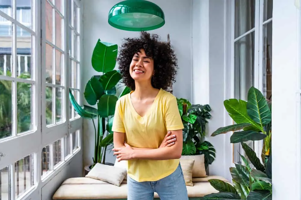 Young female with curly hair and cute laugh lines enjoying a nice sunny day at home.