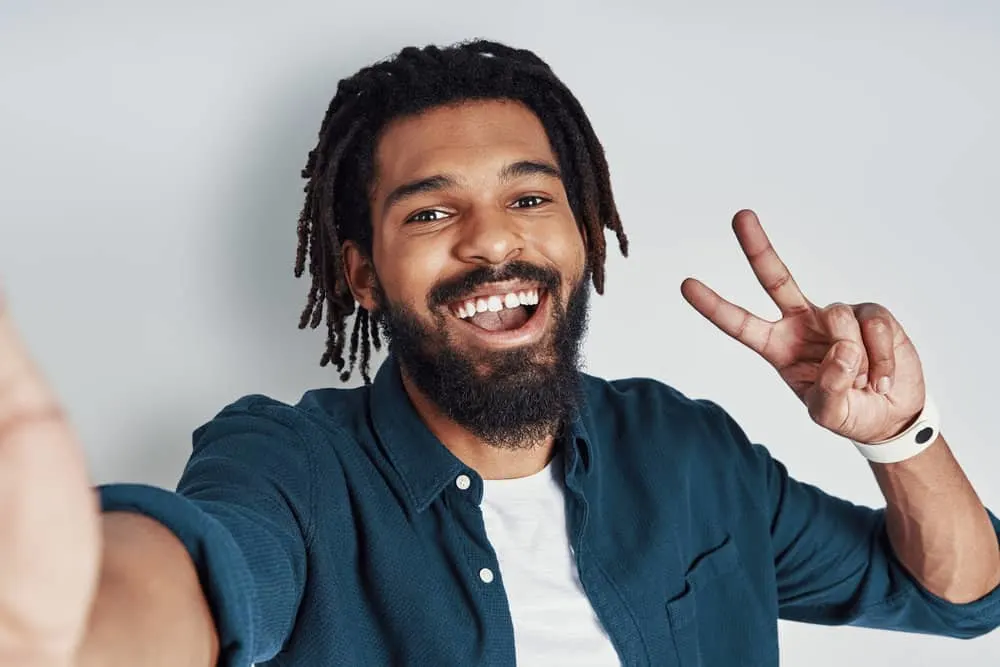 Young black guy after using a natural pre-shampoo treatment with anti-fungal properties to remove dandruff buildup.