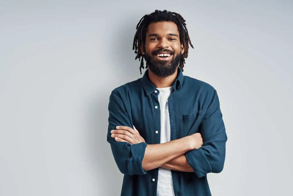 A black man with a 4B hair type and dreadlock dandruff that he treated with tea tree oil.