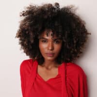 African American woman with a big curly hairdo with an amazing smell that triggers pleasure while brushing past.