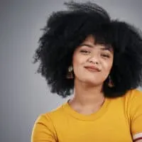 An attractive young African American woman with dark hair sees her hair turning golden brown.