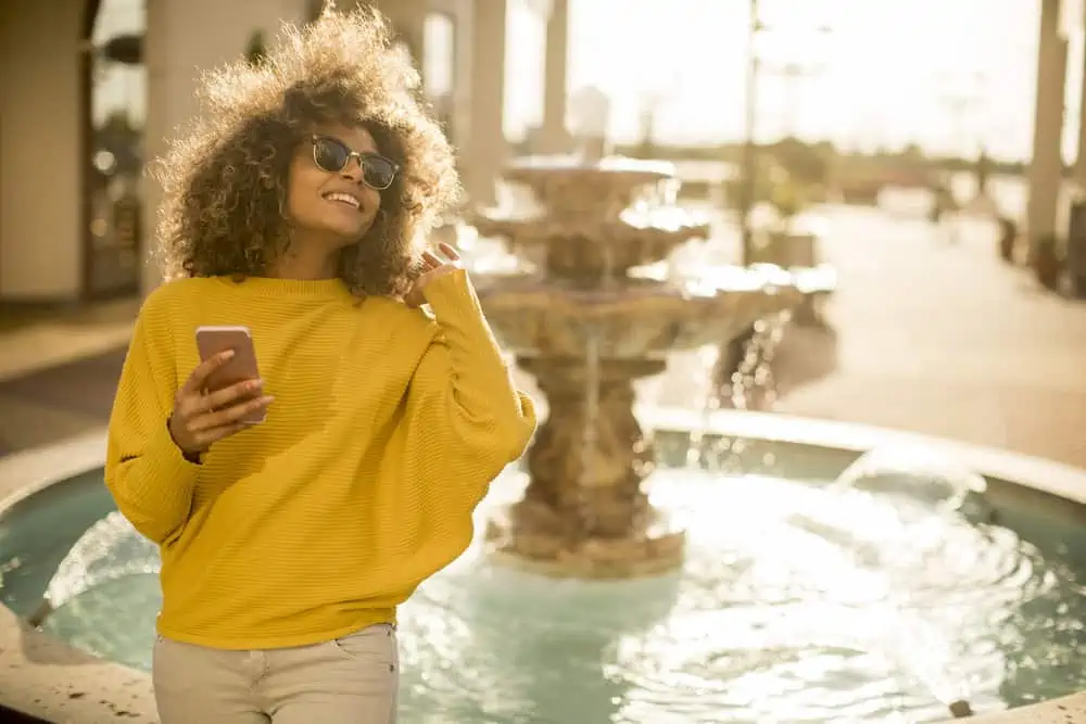 Attractive young woman with curly hair searching for a place that sells Loreal Hicolor near me.