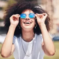 A happy black girl with curly hair follicles has been eating a healthy and balanced diet to promote hair growth.