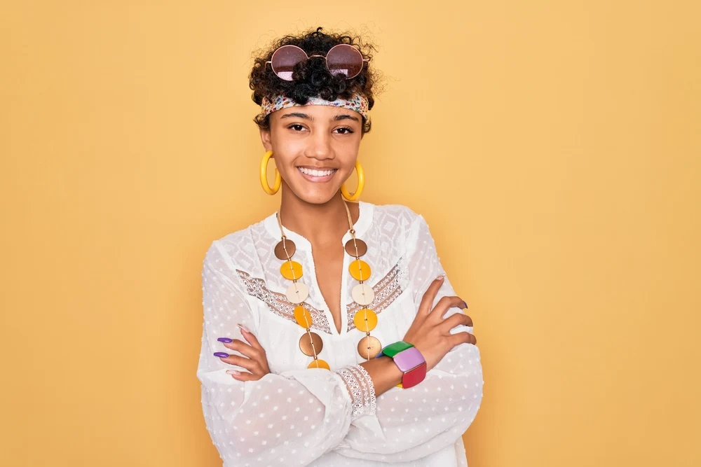 A beautiful light-skinned female wearing a shaggy bixie haircut with bangs on curly, thick hair.