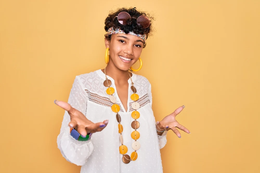 A young fashion-focused black lady wearing a long bixie haircut with a colorful bracelet and necklace.