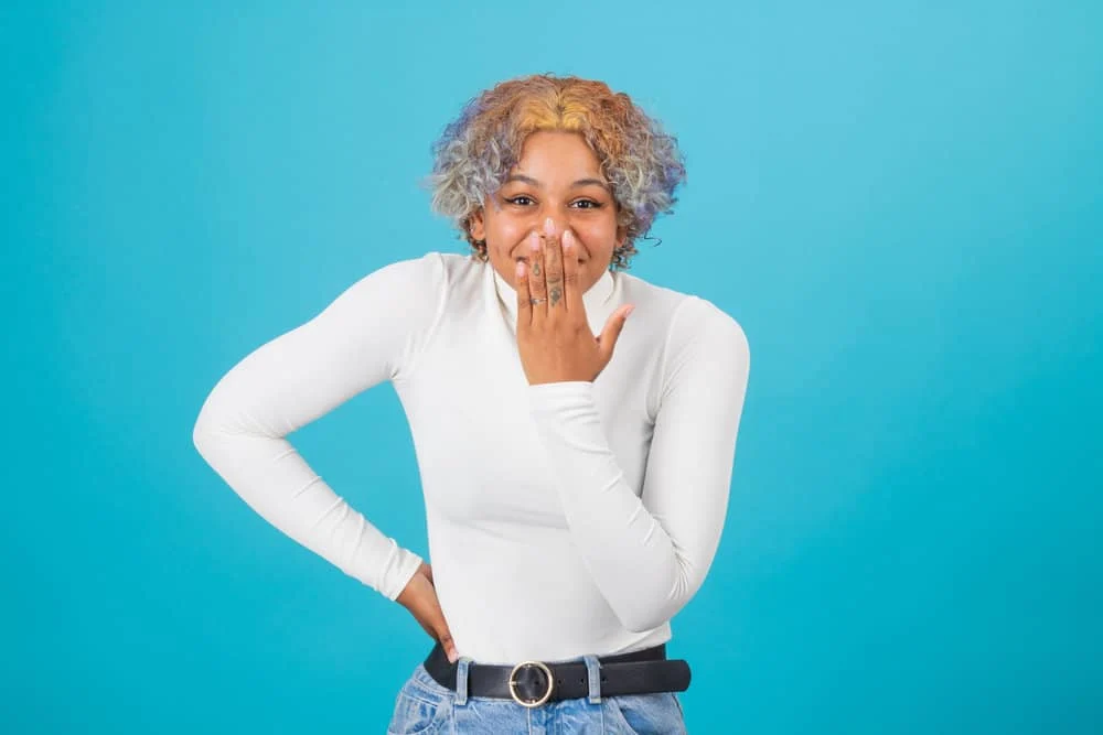 A young lady looking for color-safe products for washing colored hair to remove natural oils and excess color.