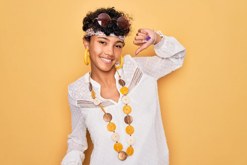 Young African American female with wispy layers wearing a shaggy bixie styled with a small round brush.