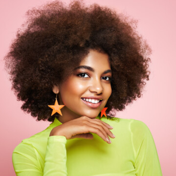 Beautiful black woman wearing one of the latest hair trends - an Alicia Keys-inspired afro with extra volume.