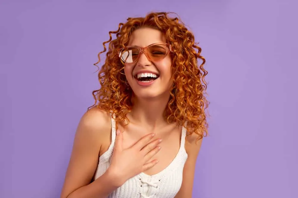 A young white lady with orange hair after using a hair toner to create a complementary color.