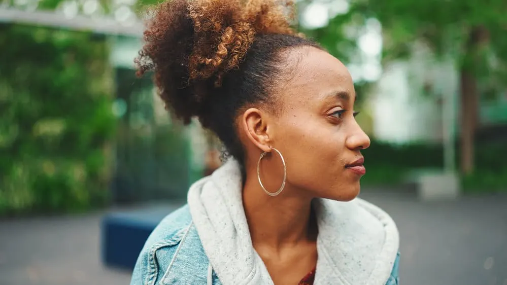 A nice black lady after bleaching hair cuticles in a unique partial blonde, brown, and black hair styled by a hair colorist. 