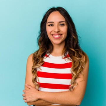 A cute young Mexican lady with semi-permanent hair dye on her dark brown ombre-colored hair follicles.