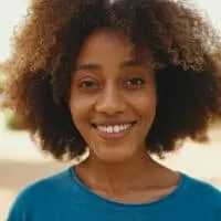 Young black girl with thick hair that is slightly wavy and curly wearing her coarse hair in an ombre style.