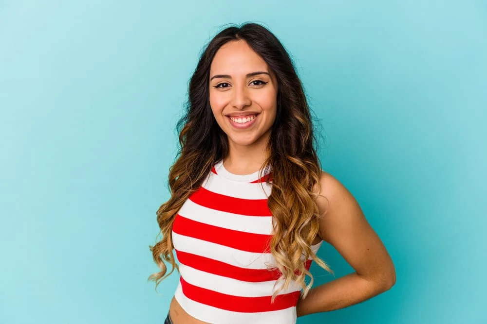 Young Mexican woman with bleached hair fibers at the ends of her naturally wavy 2C hair texture.