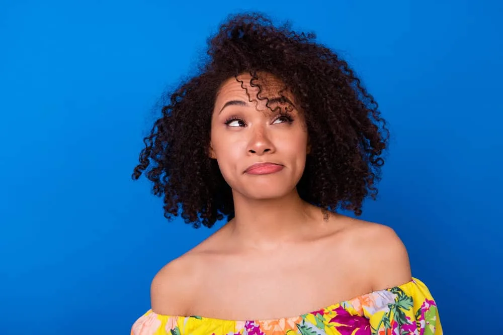 An adorable woman with wondering if keratin treatments work as she considers the chemical process for her curls.