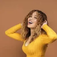 African American female with unevenly bleached hair showing very dark hair and light brown hair tones.