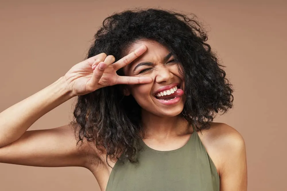 Light-skinned black girl with a brown hair strand interweaved into her long hair strands.