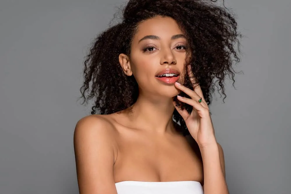 African American female with wet hair preparing to plop her natural curls with a long-sleeved t-shirt.