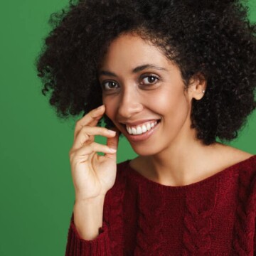 A black female with healthy hair used a protein treatment on her dry hair strands to counteract moisture overload.