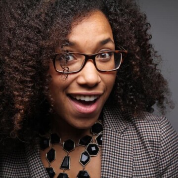 A cute African American female takes a biotin supplement to ensure she gets enough biotin to prevent hair loss.