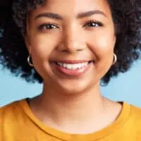 A female with curly hair follicles styled with natural hair gels and oils to prevent hair thinning and prolonged hair fall.