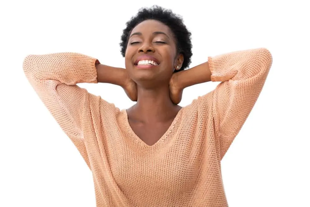 A cute African American female with a definite curl pattern showing off her natural texture with a low haircut.