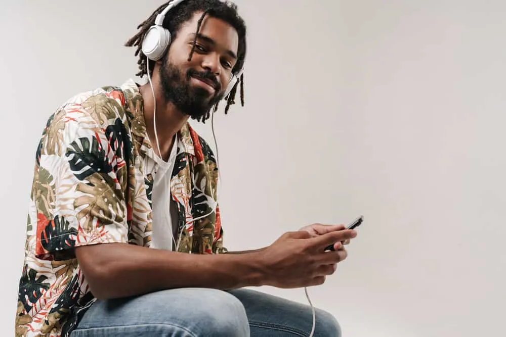 An African American man with thicker locs has used several methods to maintain his dry hair.