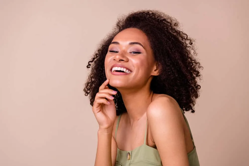 A cute young black girl with dyed hair faded with cold water following just a few washes with clarifying shampoo.