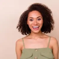 A pretty female with a dark brown natural hair color dyed with Arctic Fox hair dye on curly virgin hair strands.