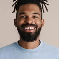 African American man with starter locs used natural hair care products, like coconut oil, to keep his hair moisturized.