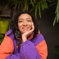 African American female with braided hair and loc extensions starting her dreadlock journey with two-strand twists.