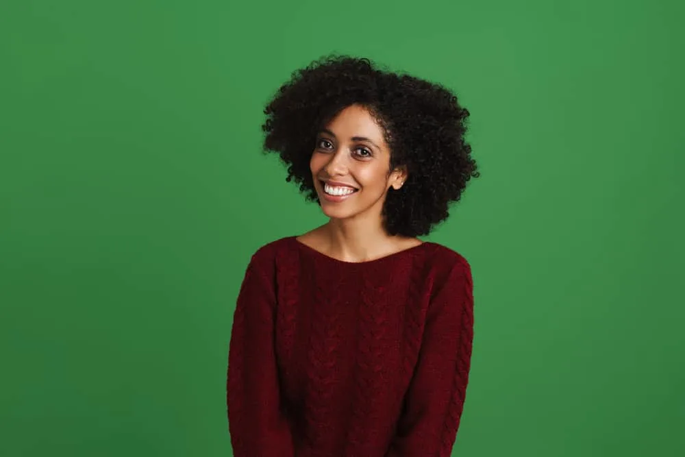 A black female with a damaged hair shaft due to protein buildup on her low porosity hair strands. 